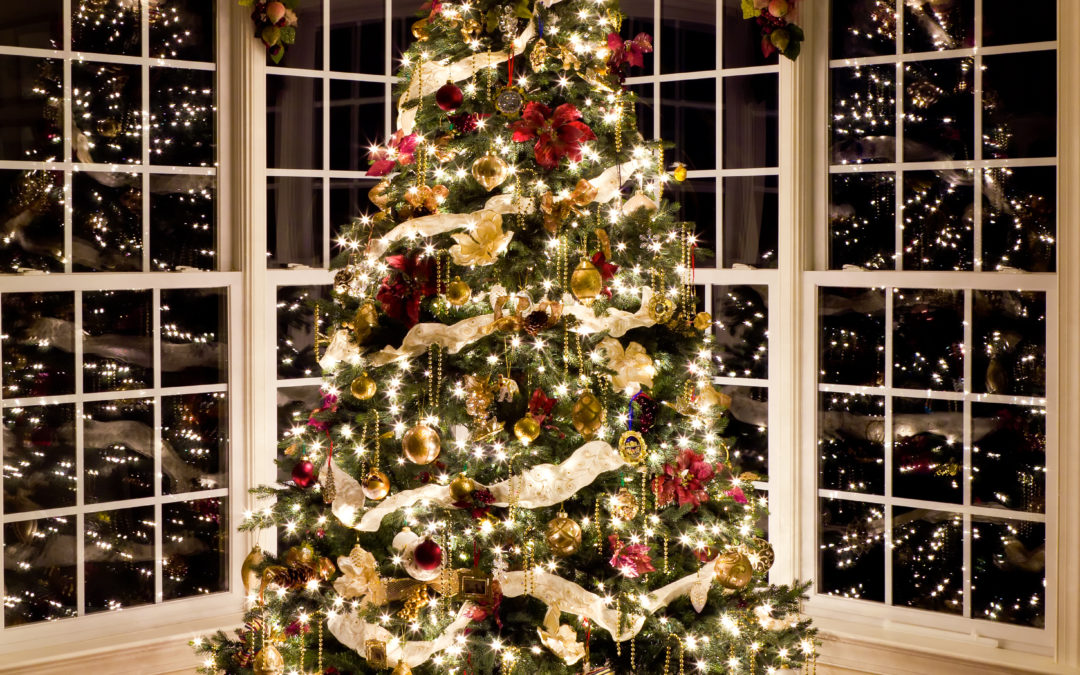 Christmas tree with presents and lights reflecting in windows around the tree in modern home